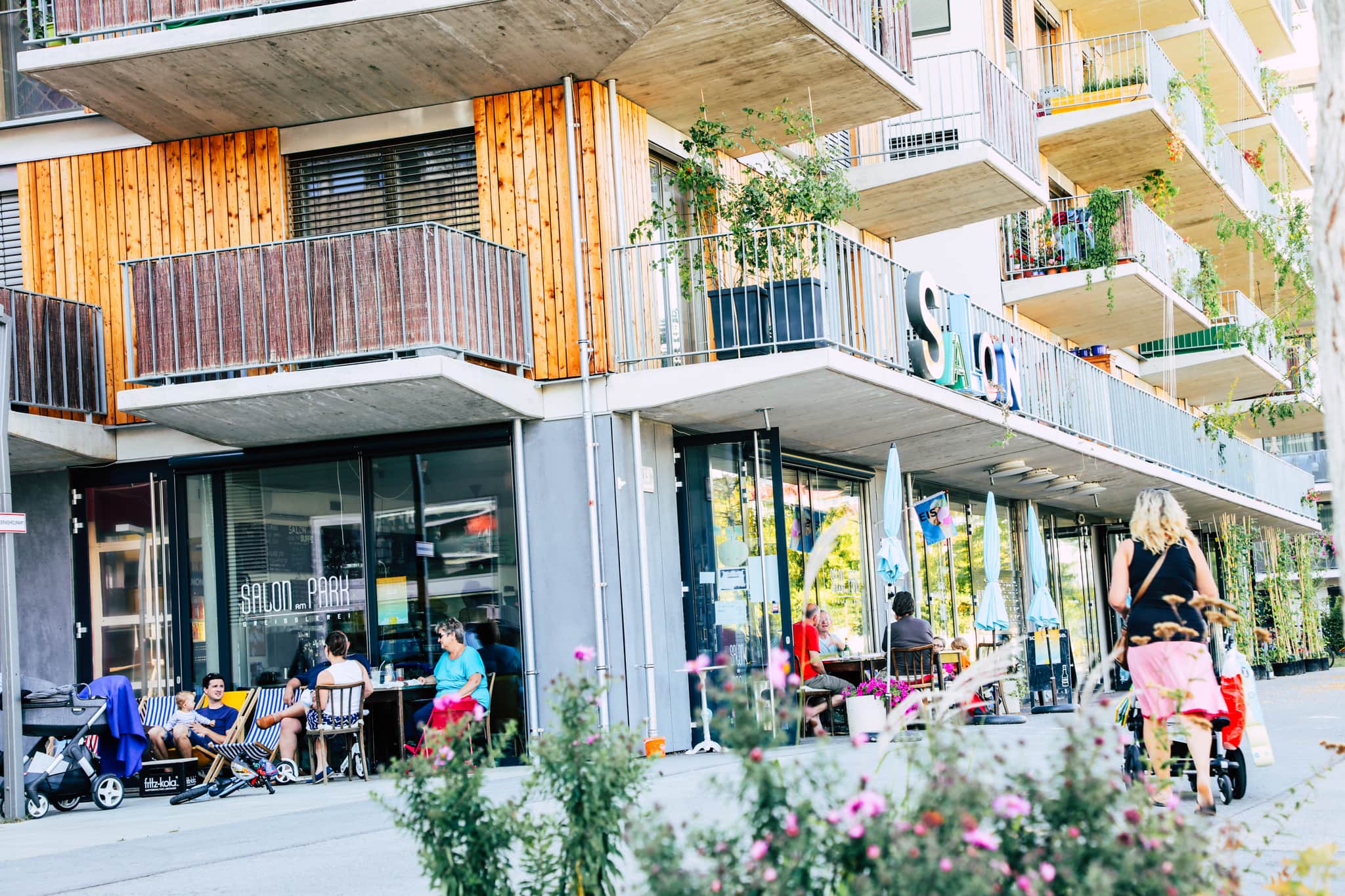 Menschen sitzen vor einem Cafe´ im Bednarpark.