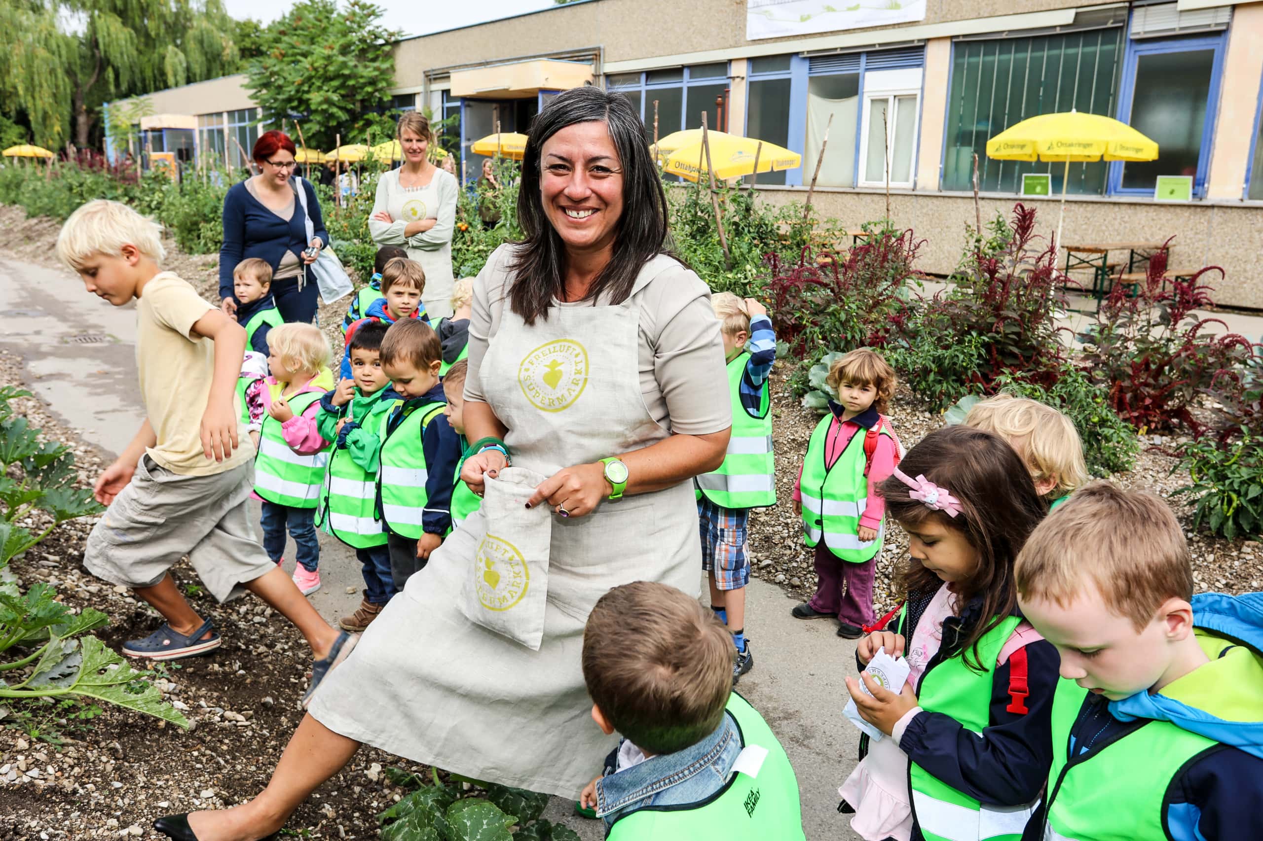 Maria Vassilakou steht mit Kindern vor einem Urban Garden.